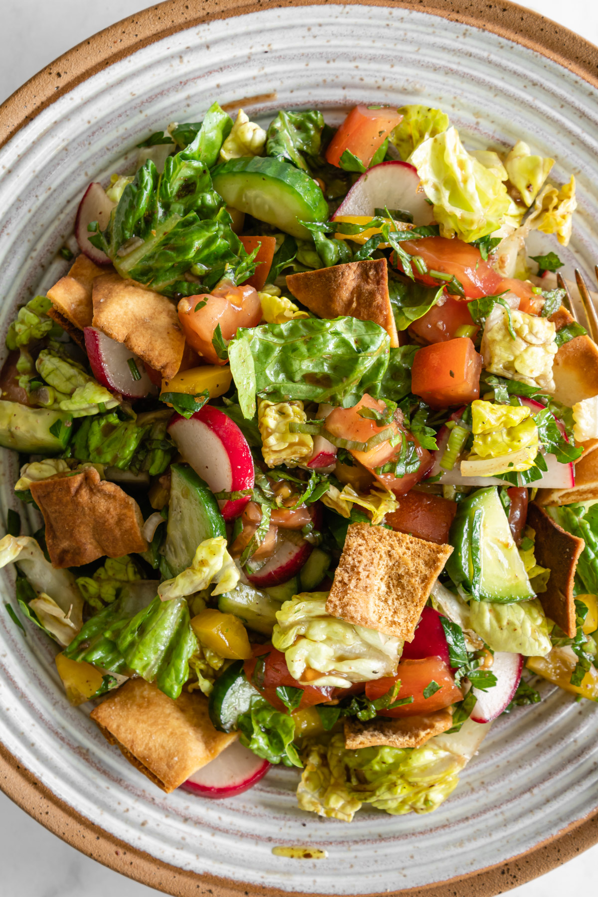 close up of fattoush salad in a ceramic bowl.