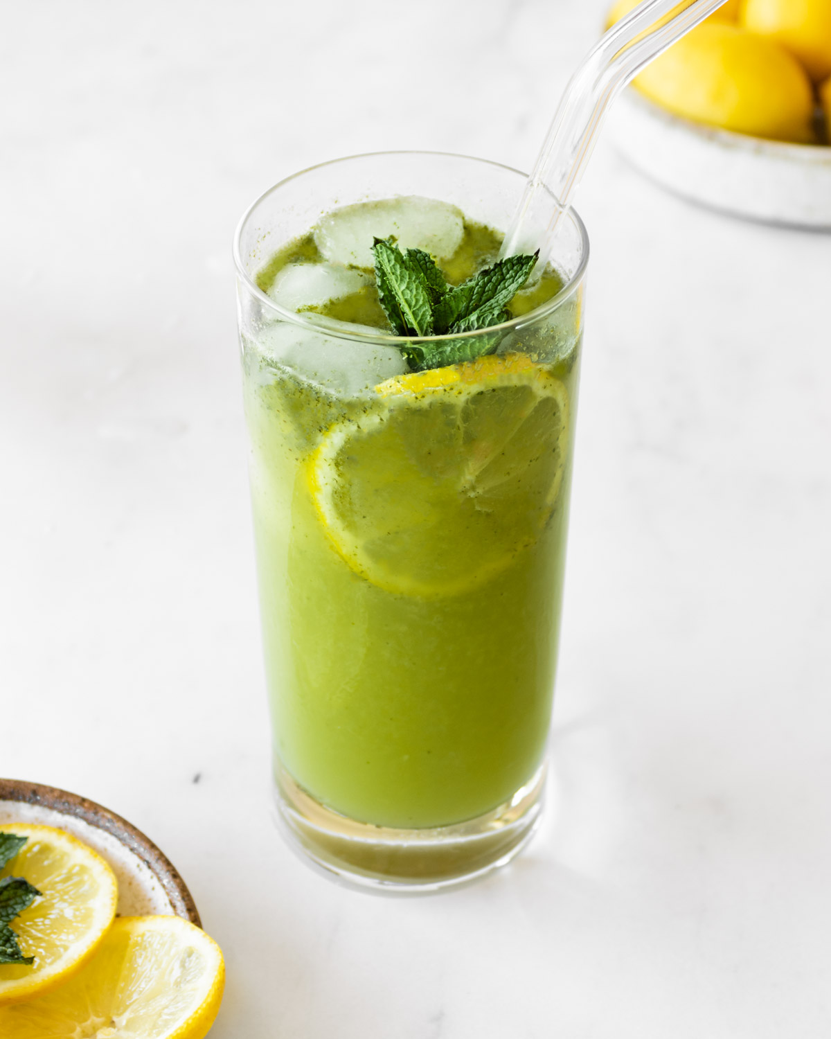 Lebanese mint lemonade in a tall glass with fresh mint leaves and a lemon slice.
