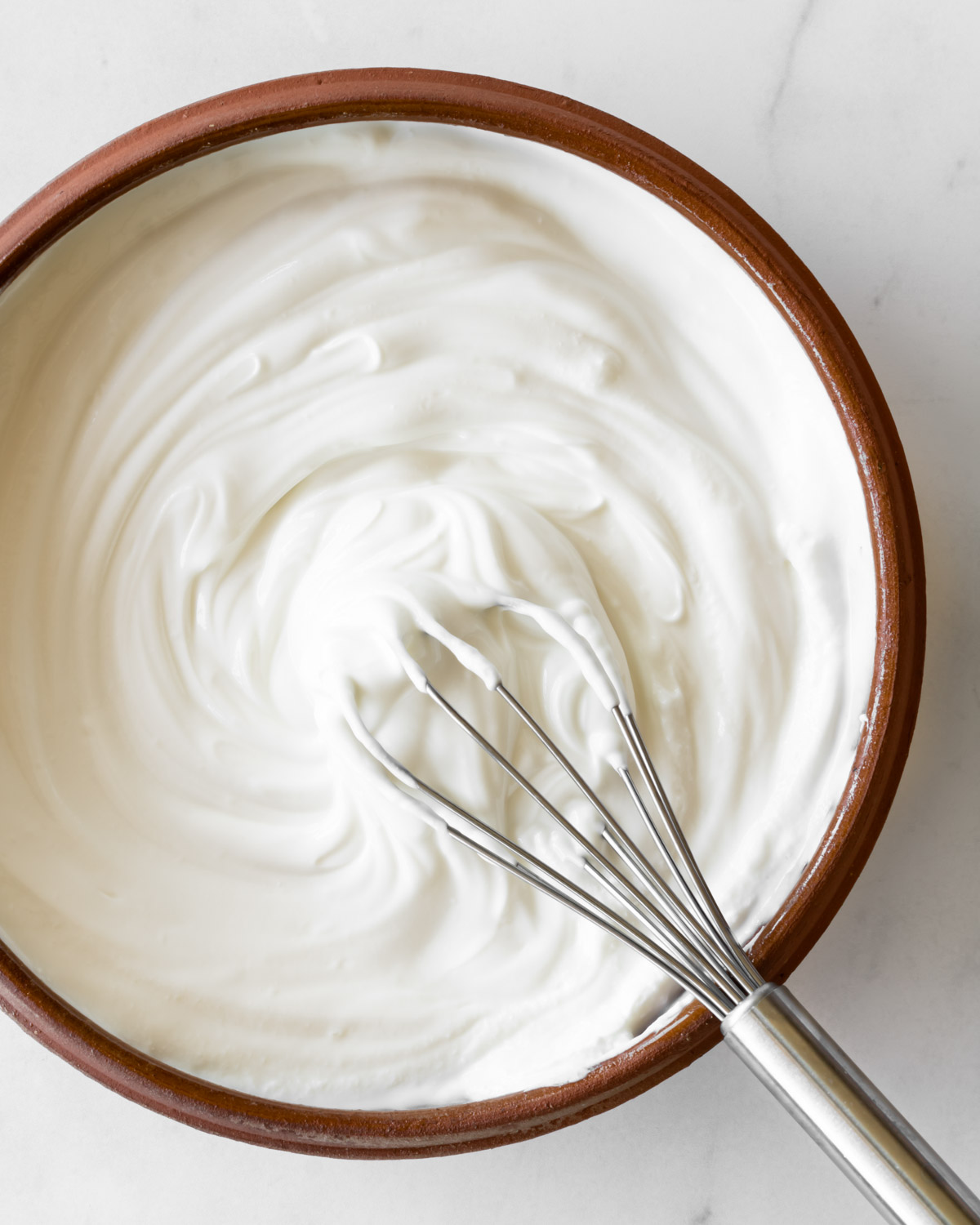 yogurt with a whisk in a bowl.