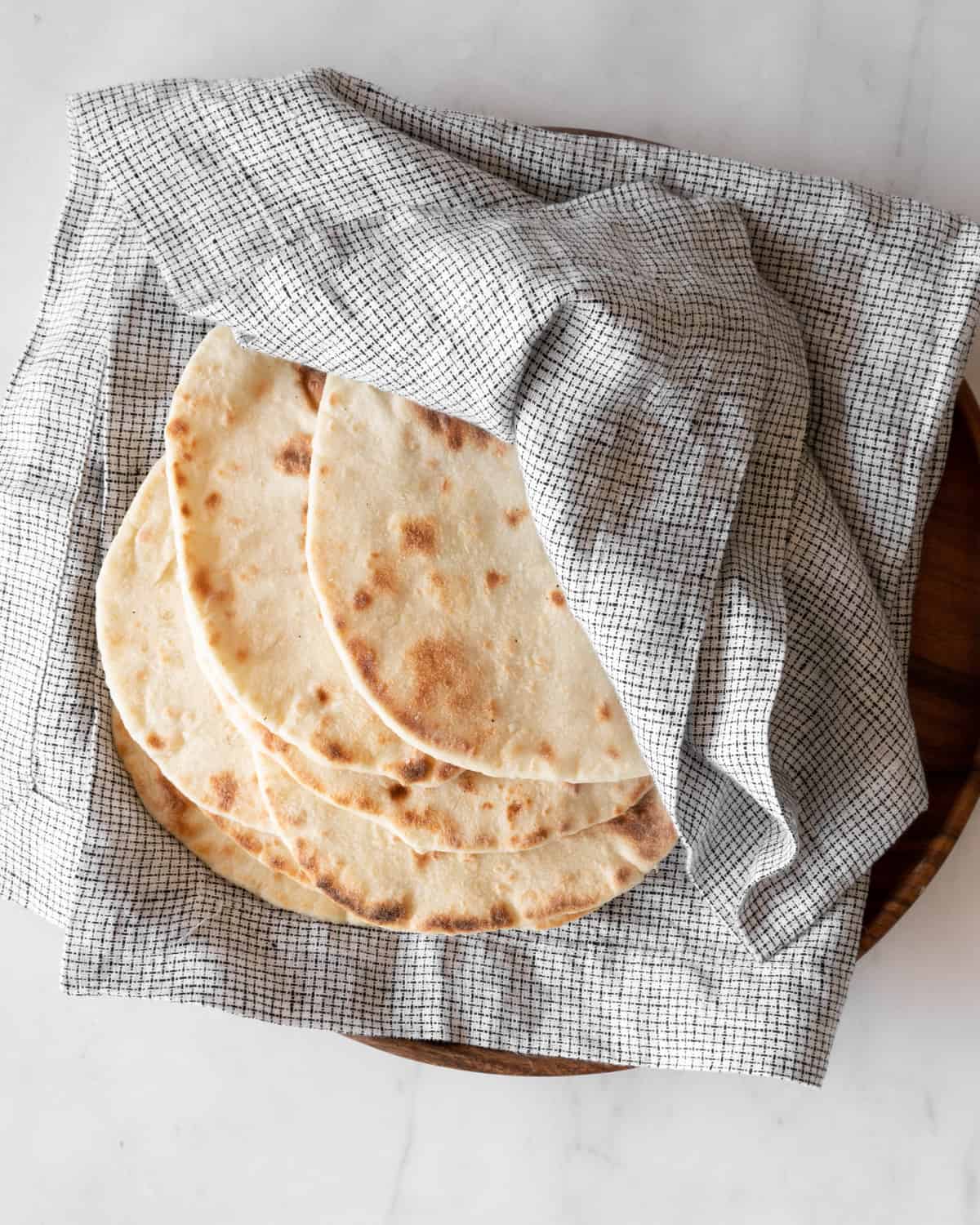two-ingredient pita bread in a linen on a wooden plate.