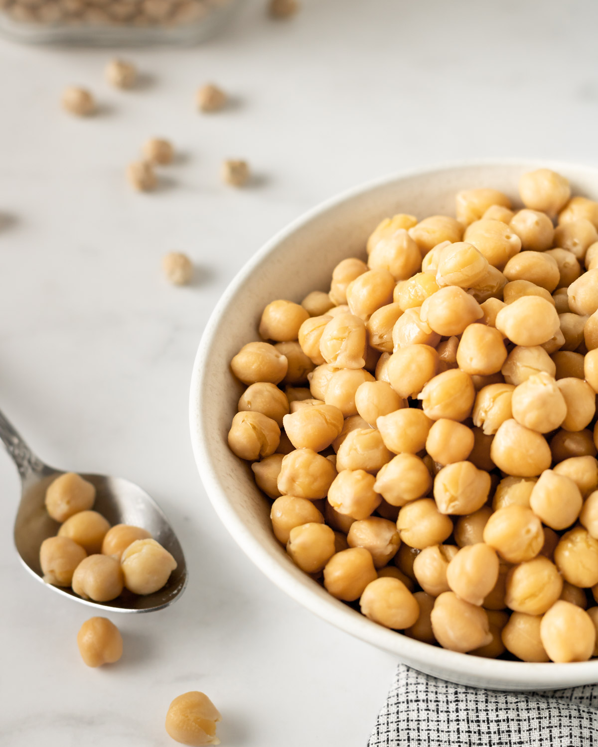 bowl of cooked chickpeas and a spoon on the side.