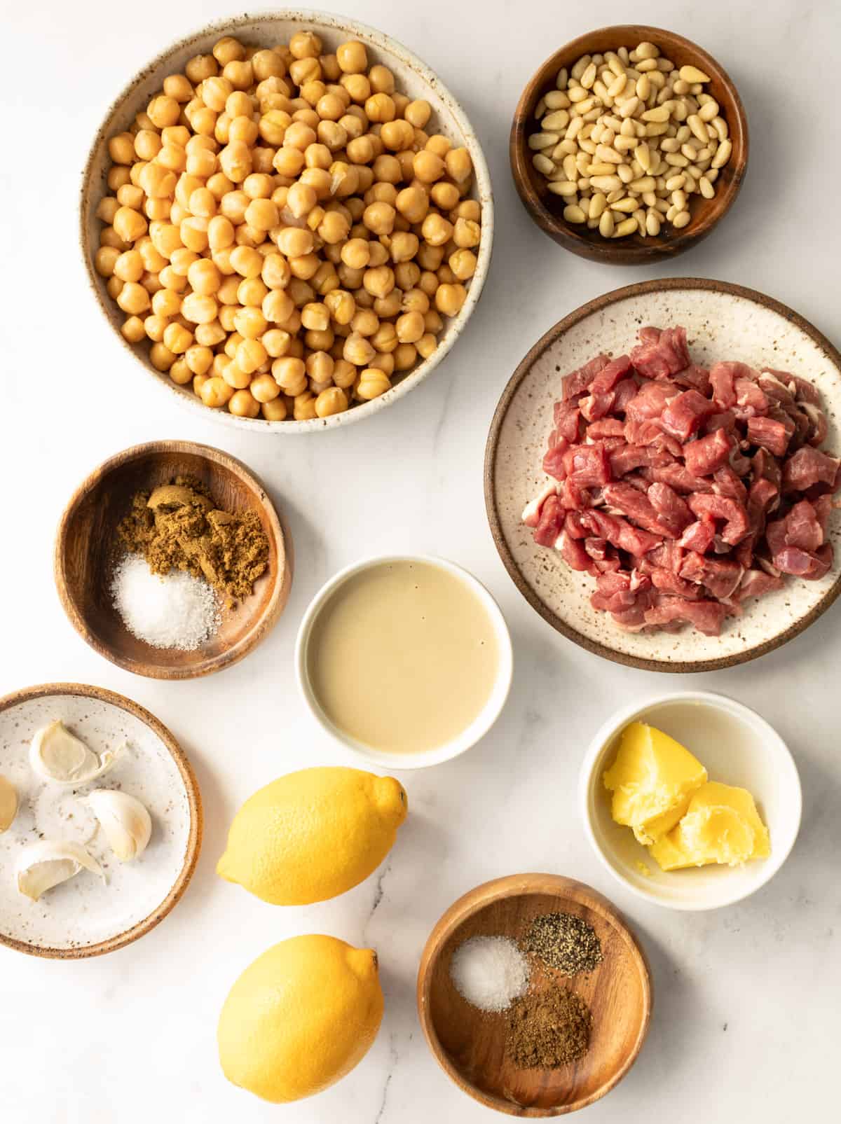 ingredients to make hummus with spiced meat and pine nuts.