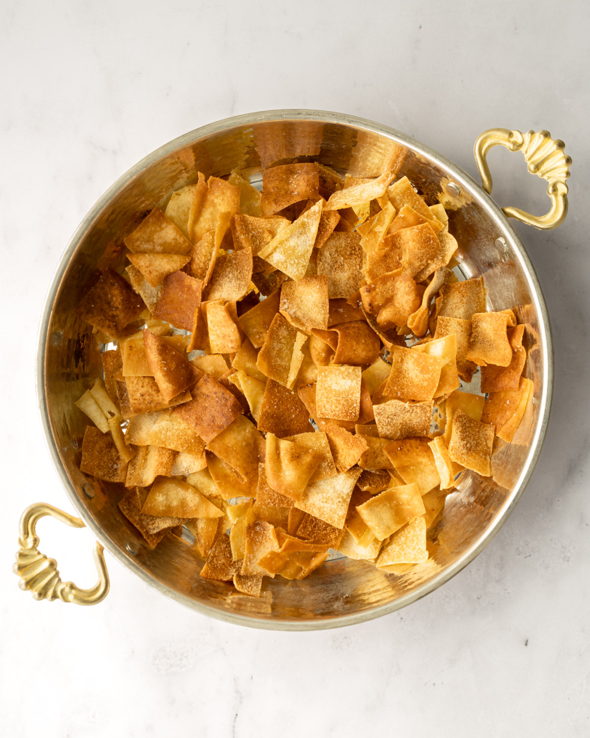 a shallow bowl with a layer of toasted pita chips.