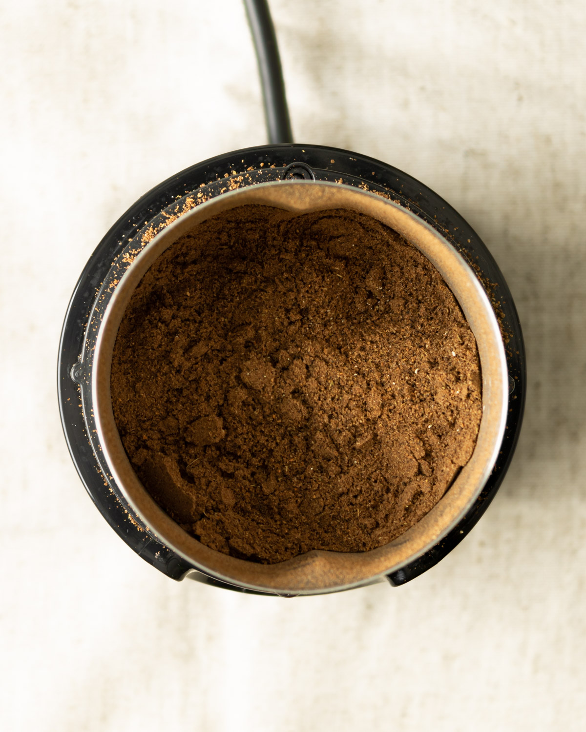 ground up spices inside the electric spice grinder.